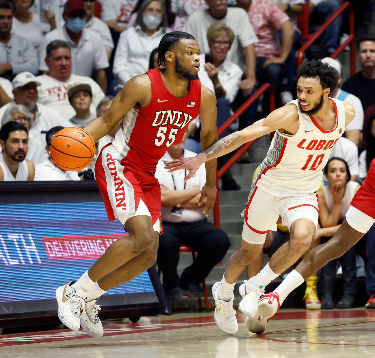UNLV's Elijah Harkless dribbles past New Mexico's Jaelen House in the second half of an NCAA co ...