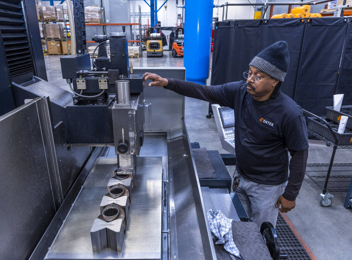ENTEK's Michael Jones grinds finished parts in their machine shop area during a press tour, the ...