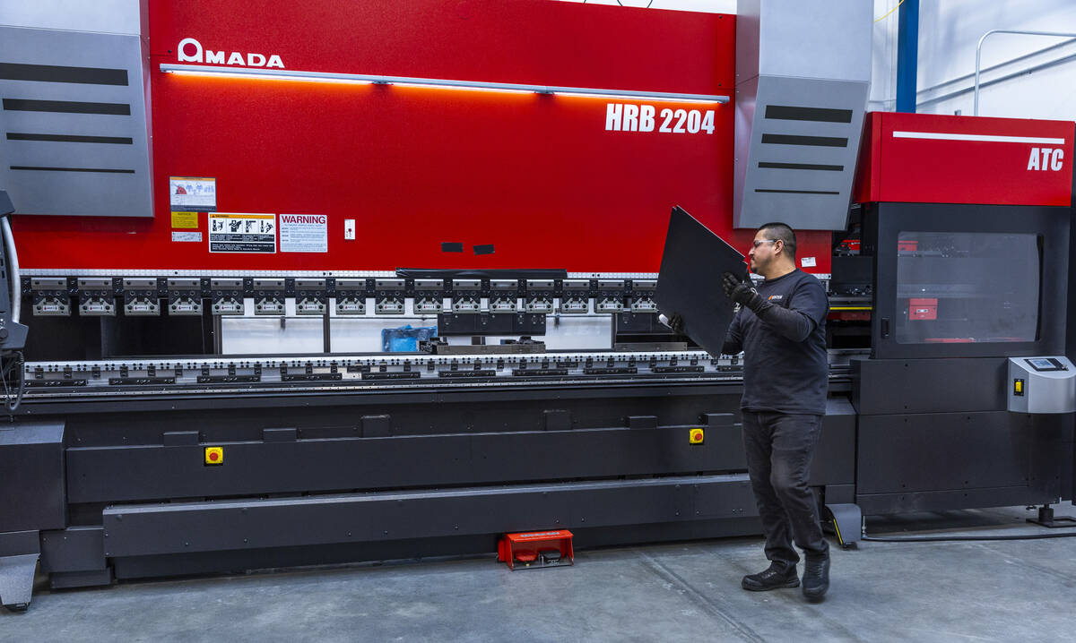 ENTEK's Jorge Amaro works their new Amada sheet metal press machine during a press tour, the co ...
