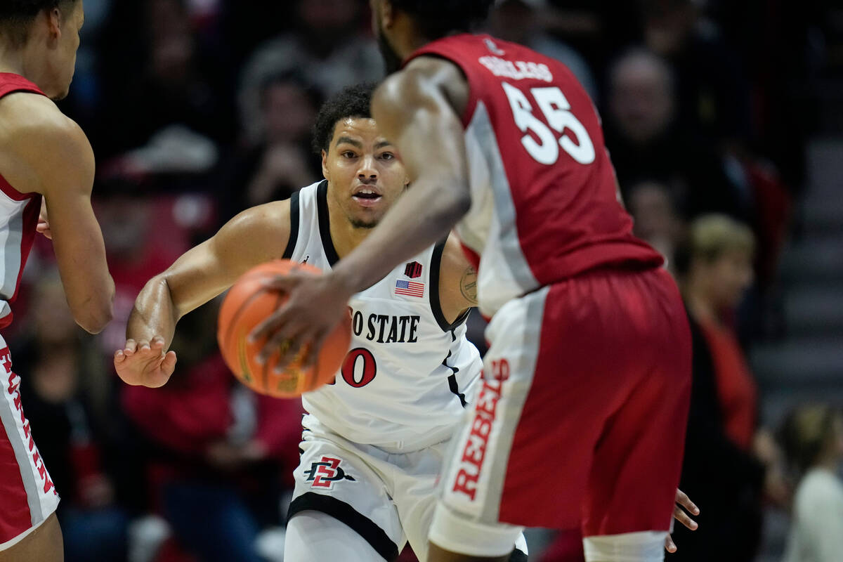 San Diego State guard Matt Bradley, center, defends as UNLV guard EJ Harkless , right, dribbles ...