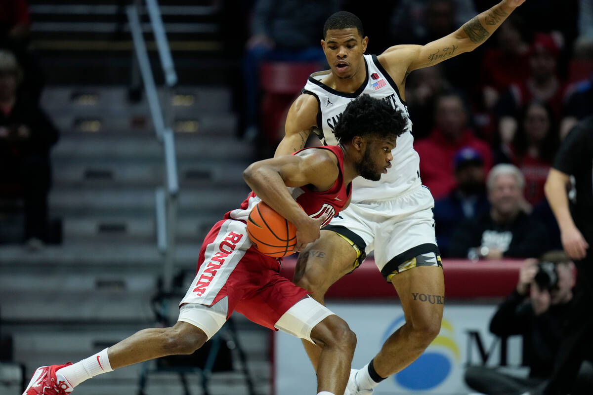 UNLV guard EJ Harkless drives with the ball as San Diego State forward Keshad Johnson defends d ...