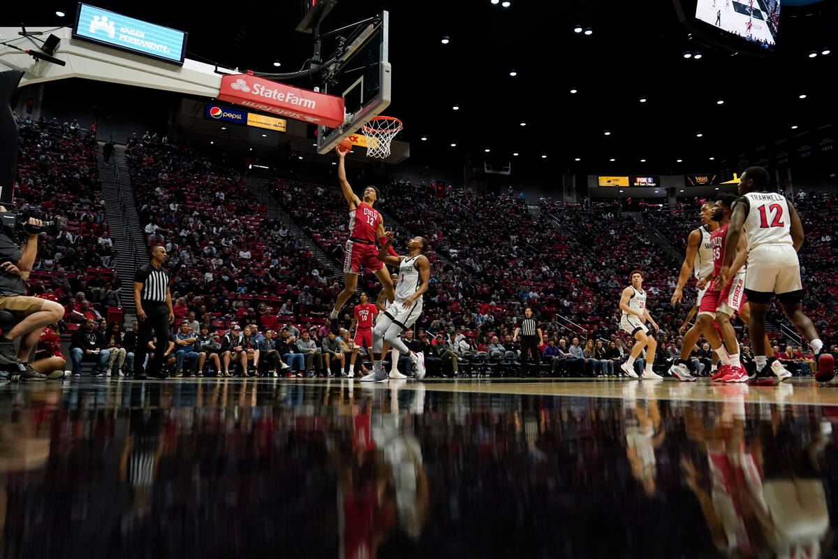 UNLV center David Muoka (12) shoots as San Diego State guard Micah Parrish looks on, below, dur ...