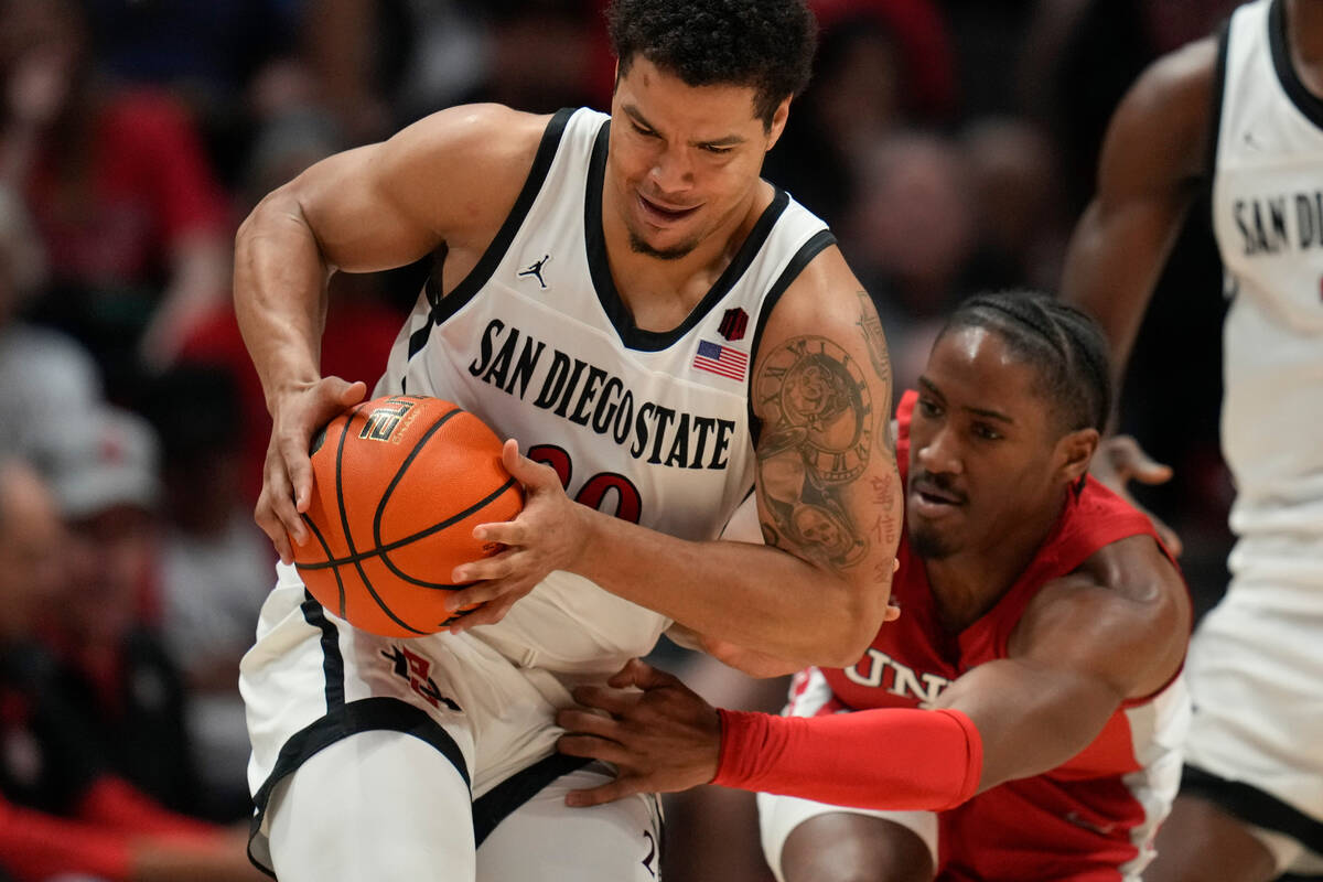 San Diego State guard Matt Bradley, left, holds on to the ball as UNLV guard Shane Nowell reach ...