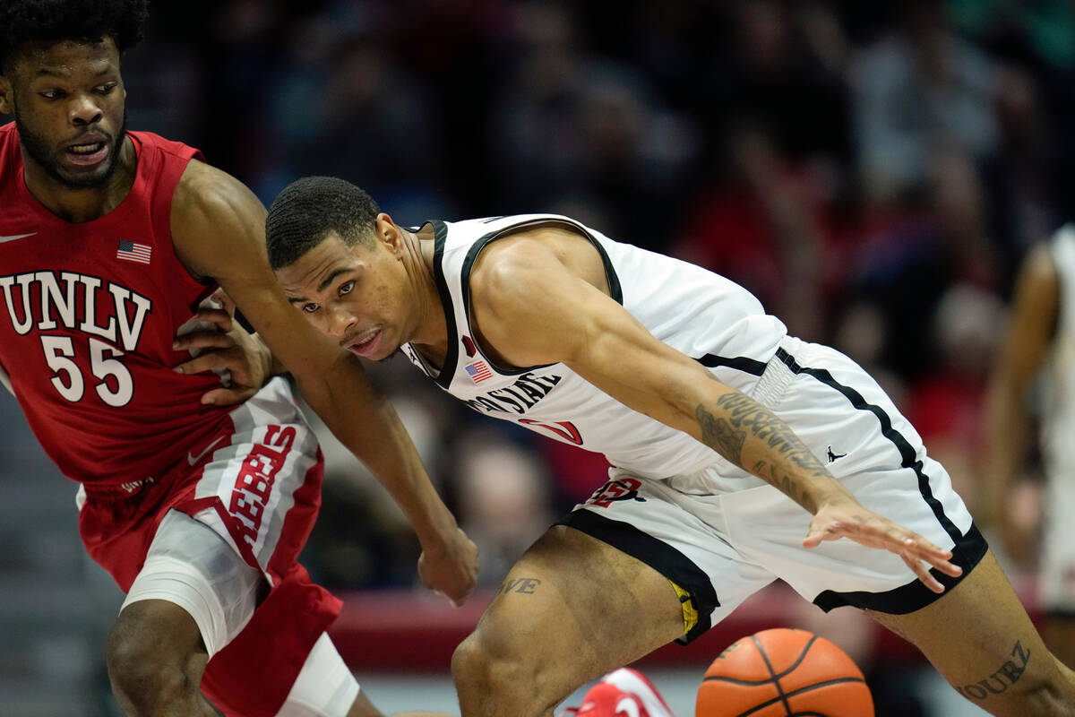 San Diego State forward Keshad Johnson, right, drives with the ball as UNLV guard EJ Harkless d ...