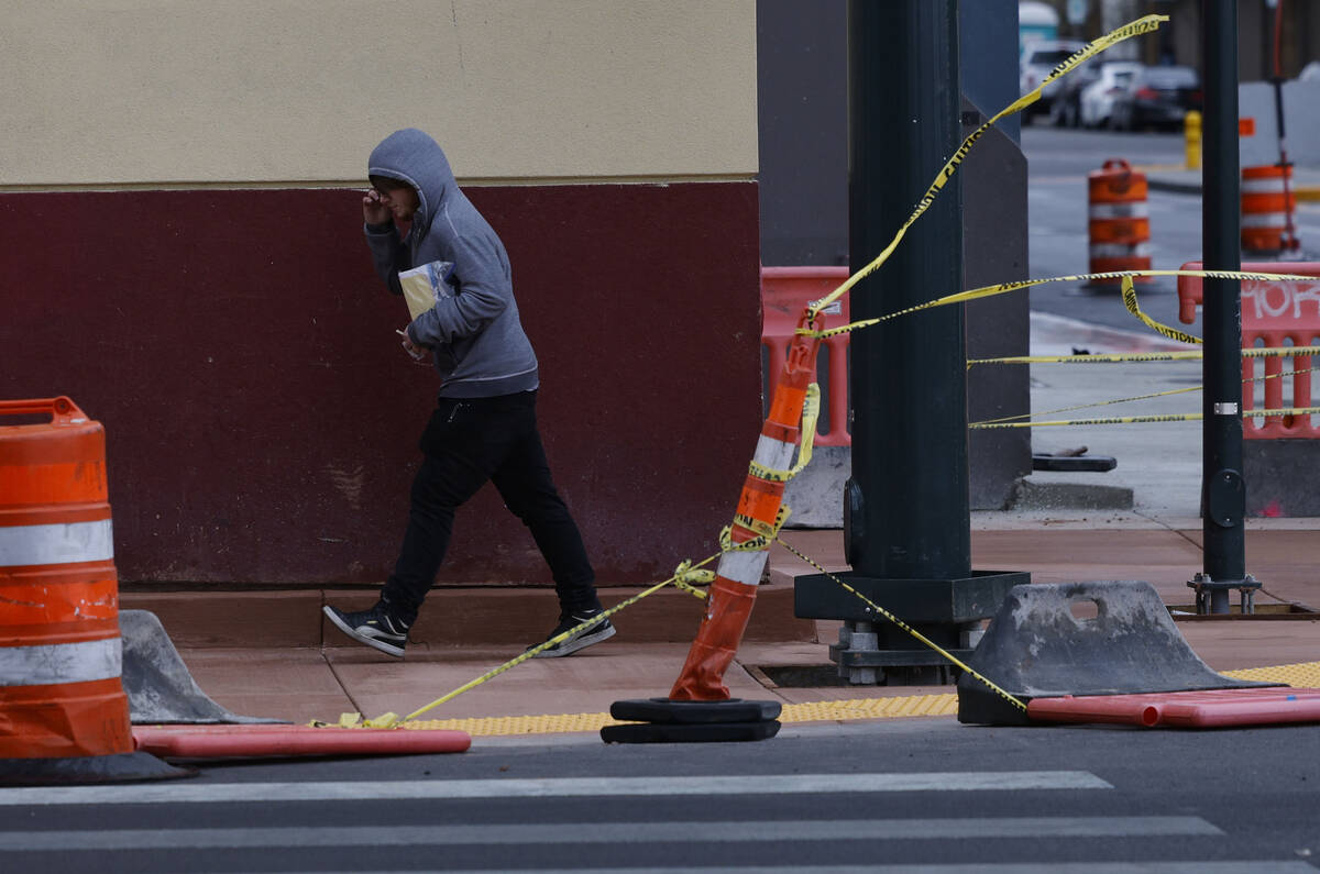 A pedestrian walks against strong wind, Tuesday, Feb. 14, 2023, in downtown Las Vegas. (Chitose ...