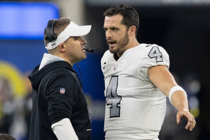 Raiders quarterback Derek Carr (4) and Raiders head coach Josh McDaniels speak during the secon ...