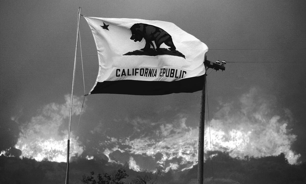 The California state flag flies next to a home on Highway 94 south Potrero, Calif., on Monday, ...