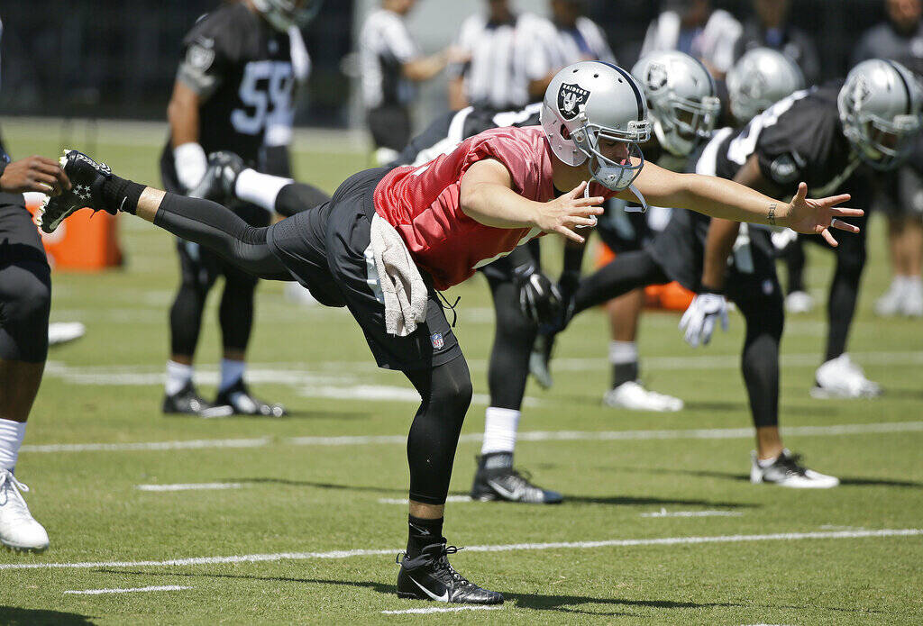 FILE - In this June 14, 2016, file photo, Oakland Raiders quarterback Derek Carr stretches duri ...
