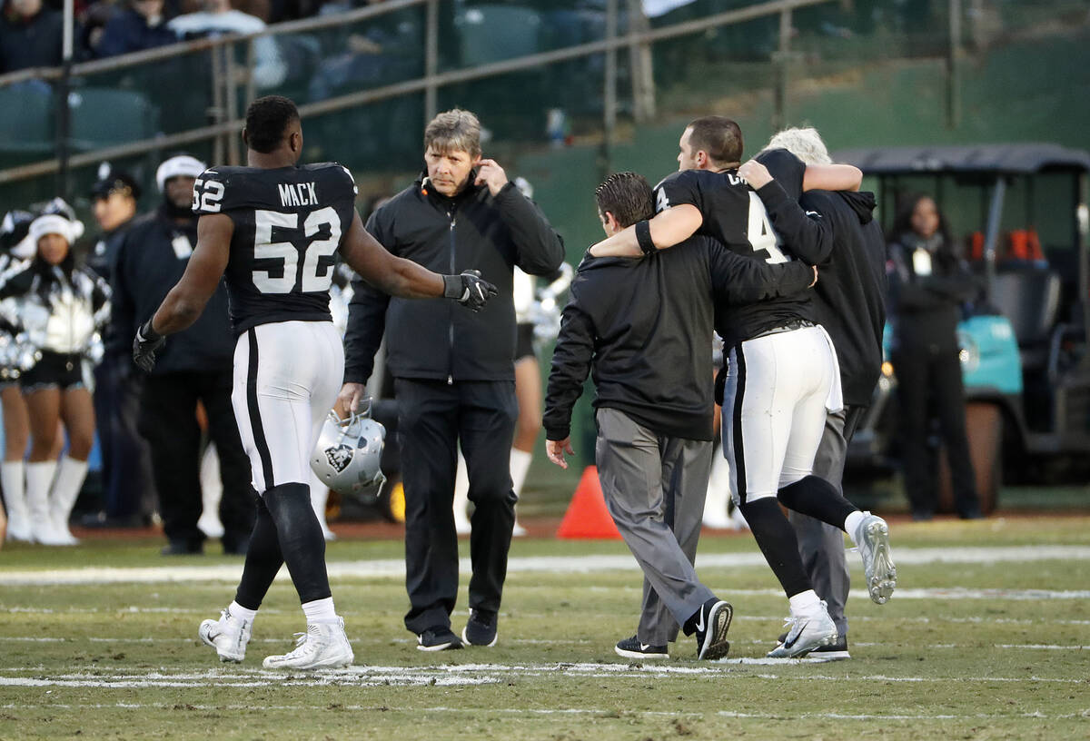 Oakland Raiders quarterback Derek Carr (4) is helped off the field with an injury during the se ...