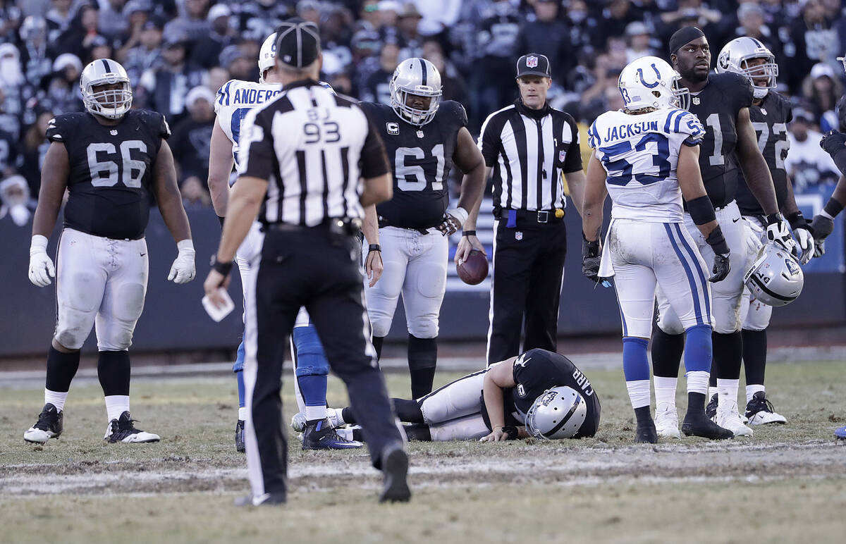 Oakland Raiders quarterback Derek Carr remains on the field with an injury during the second ha ...