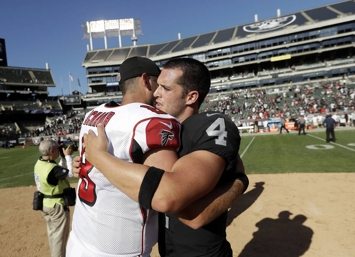 Atlanta Falcons quarterback Matt Schaub, left, hugs Oakland Raiders quarterback Derek Carr (4) ...