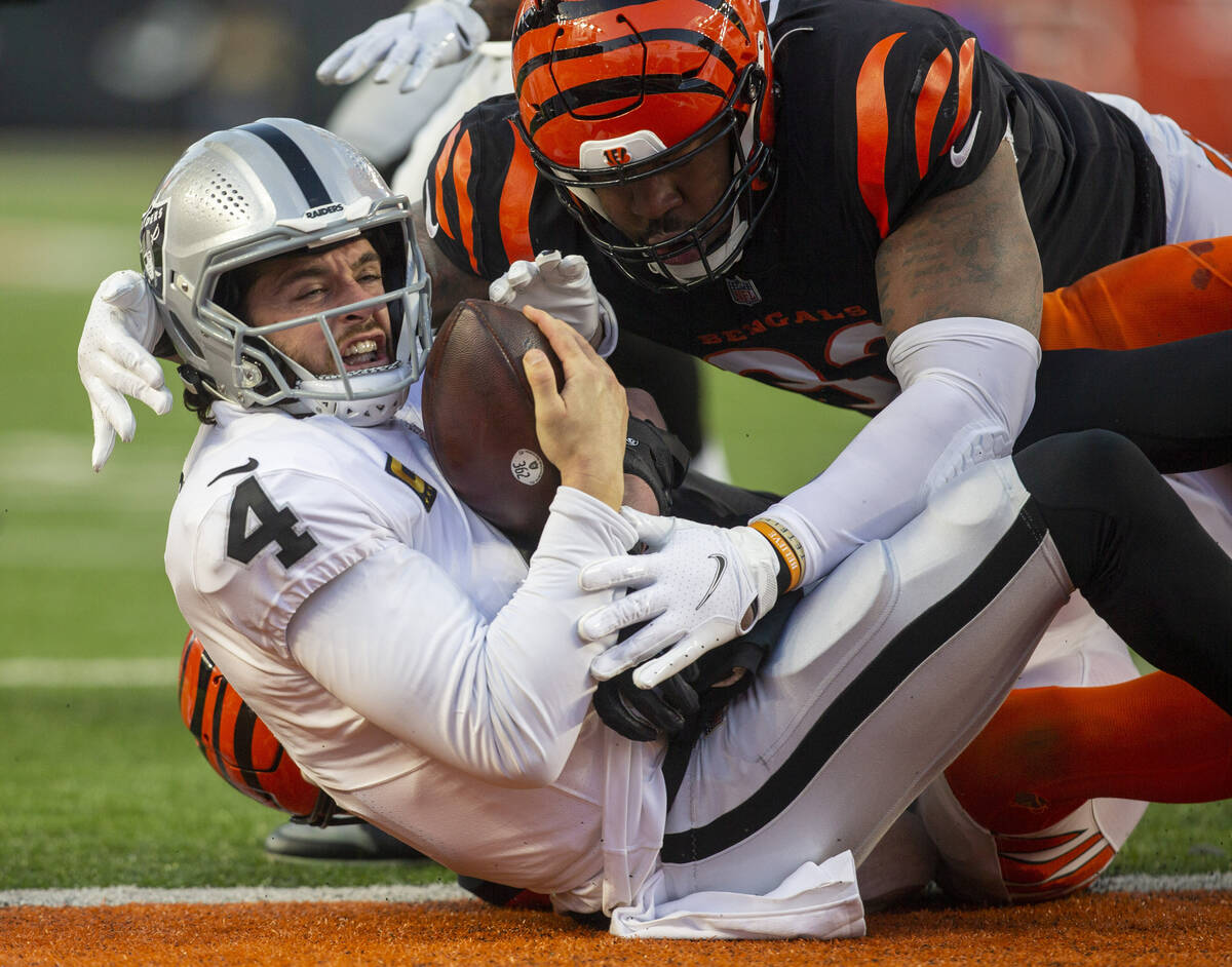 Raiders quarterback Derek Carr (4) holds on to the football as he is sacked by Cincinnati Benga ...
