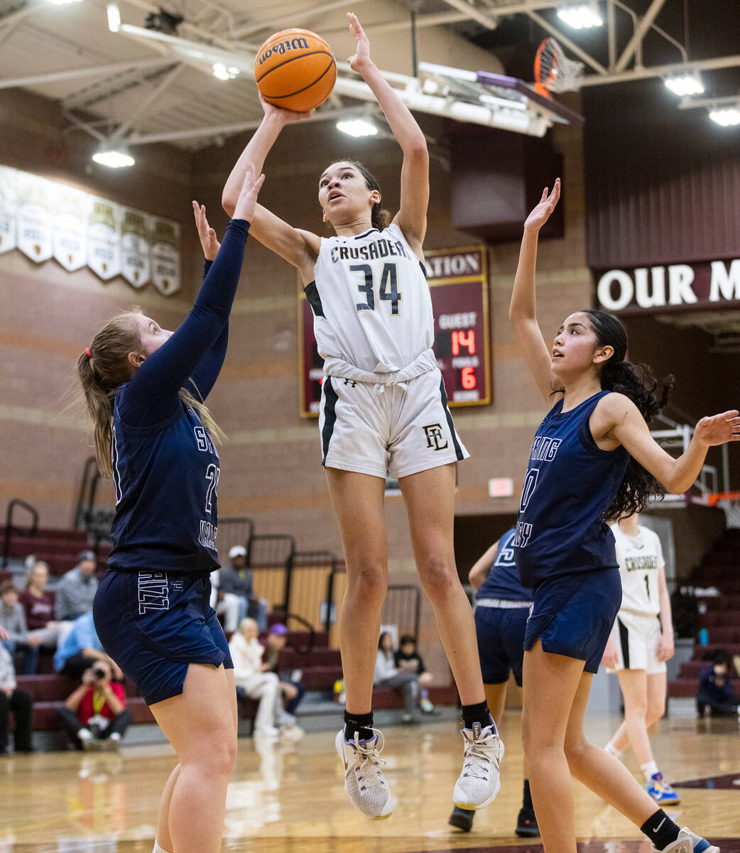Faith Lutheran's Leah Mitchell (34) shoots for the basket between Spring Valley's high Delaney ...