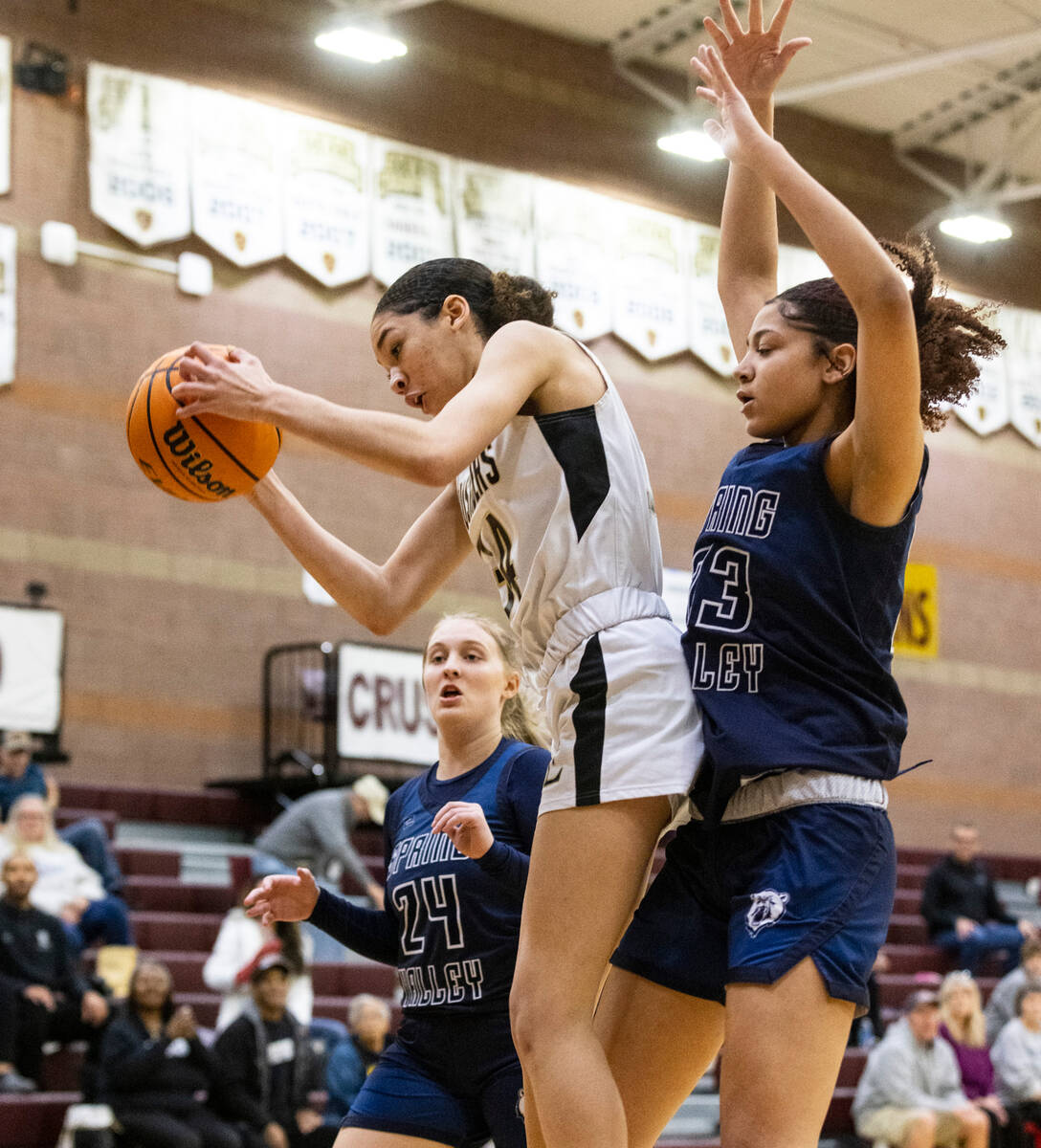 Faith Lutheran's Leah Mitchell (34) goes for the rebound as Spring Valley's high Delaney Bartle ...