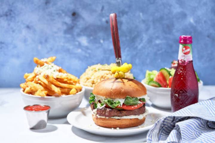 A Meráki steak burger, front, and from left, feta fries, Greek rice and a classic Greek salad. ...