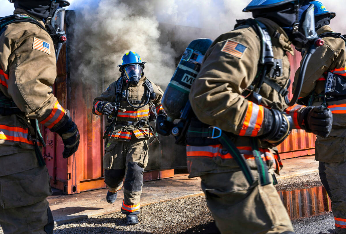 Clark County Fire Department recruits exit a smoky trailer on hands and knees during live fire ...