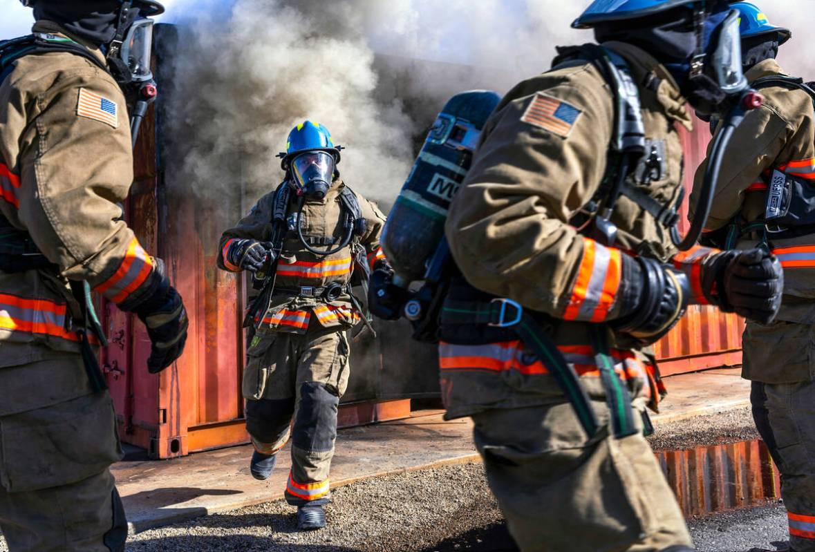 Clark County Fire Department recruits exit a smoky trailer on hands and knees during live fire ...