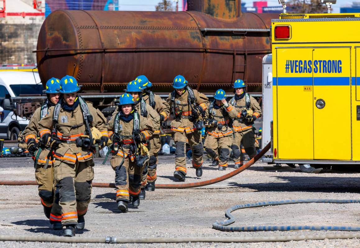 Clark County Fire Department recruits run in their turnout gear for live fire training within a ...