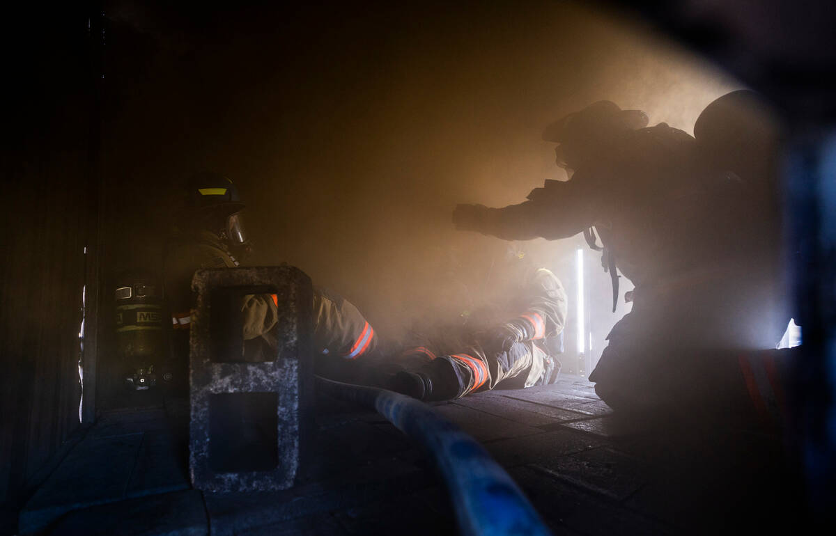 Clark County Fire Department recruits experience low visibility within a smoky trailer during l ...