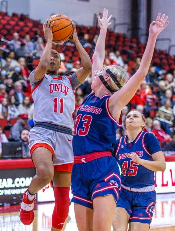 UNLV Lady Rebels guard Justice Ethridge (11) posts up for a shot over Fresno State Bulldogs for ...