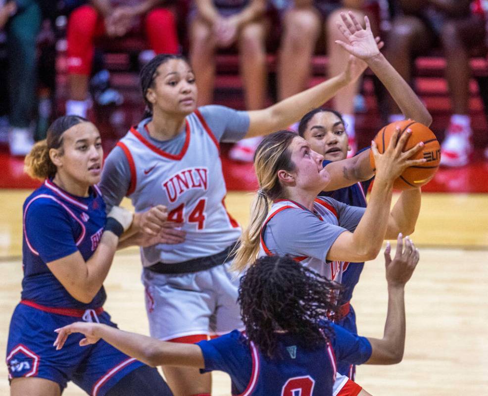 UNLV Lady Rebels guard Kenadee Winfrey (2) drives past Fresno State Bulldogs guard Keely Brown ...