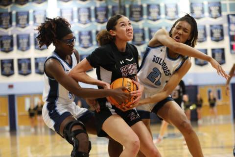 Faith Lutheran's Leah Mitchell (34) is blocked while taking a shot under pressure from Centenni ...