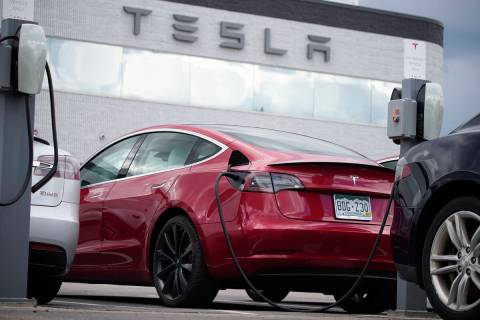 FILE - A 2021 Model 3 sedan sits in a near-empty lot at a Tesla dealership in Littleton, Colo. ...