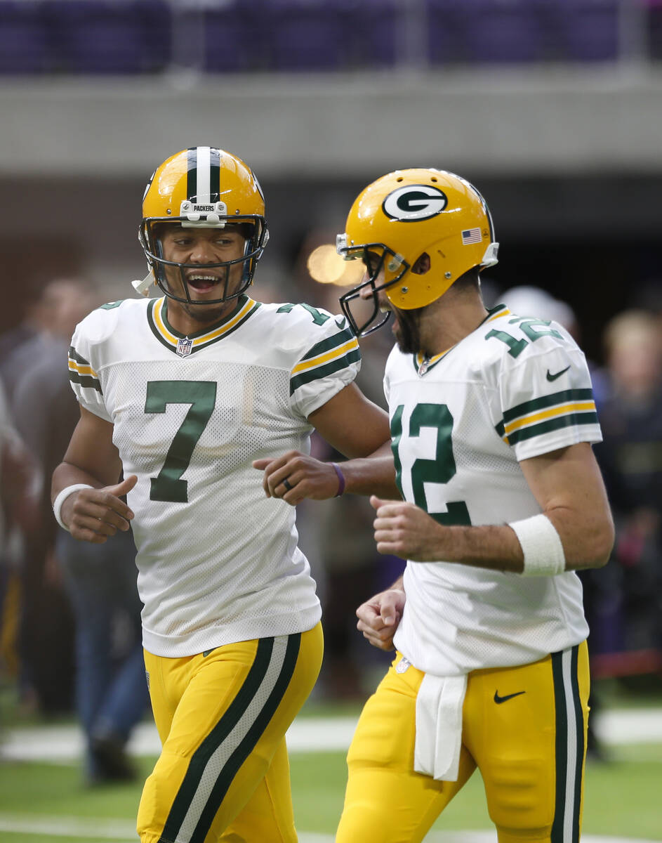 Green Bay Packers quarterback's Brett Hundley (7) runs with Aaron Rodgers (12) before an NFL fo ...