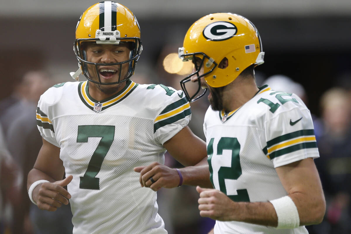 Green Bay Packers quarterback's Brett Hundley (7) runs with Aaron Rodgers (12) before an NFL fo ...