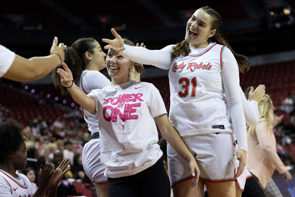 UNLV Lady Rebels guard Ashley Scoggin, left, and center Erica Collins (31) celebrate on the ben ...