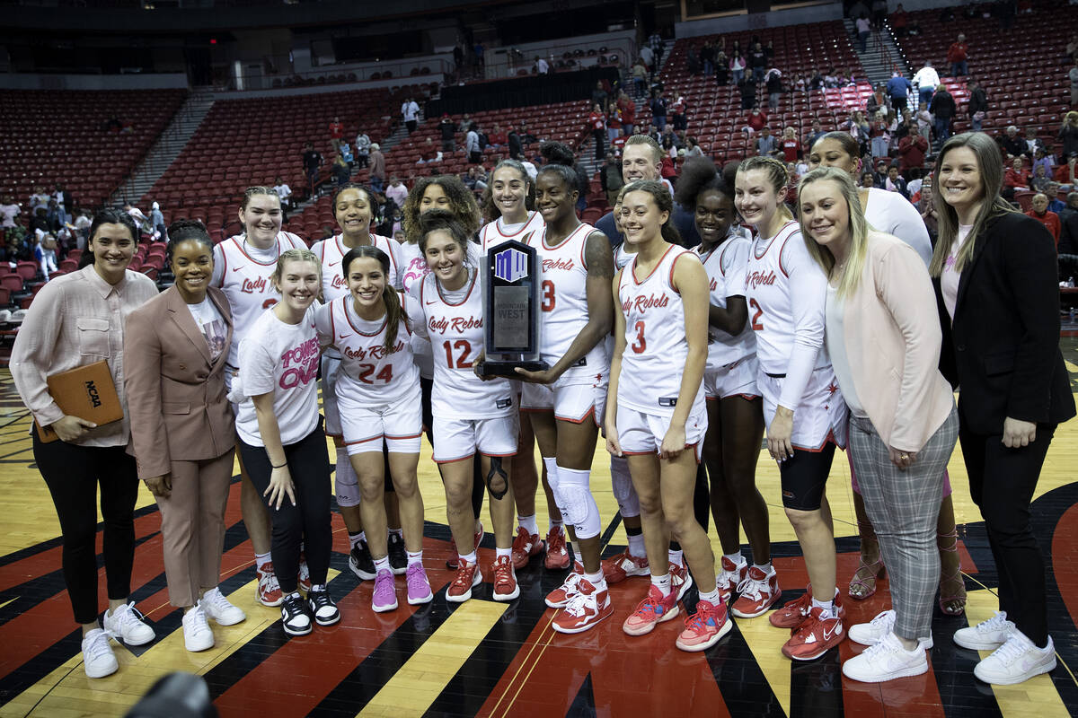 The UNLV Lady Rebels pose for photos after winning an NCAA college basketball game against the ...