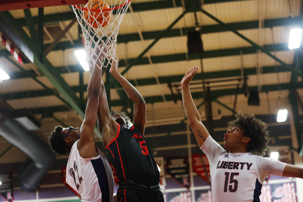 Liberty's Javares Reid (22) and Carlos Bradley (15) defend a shot by Coronado's Lantz Stephens ...