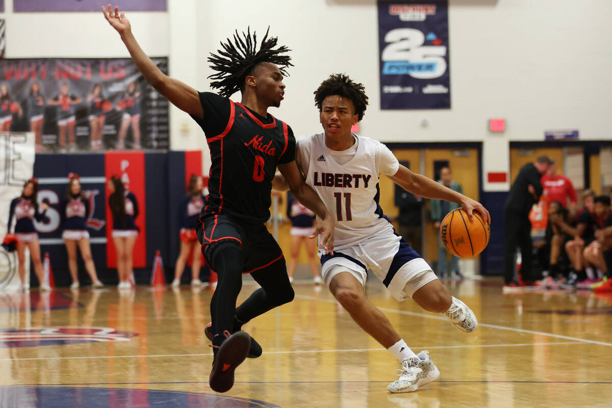 Liberty's Dedan Thomas (11) dribbles the ball to the basket under pressure from Coronado's John ...