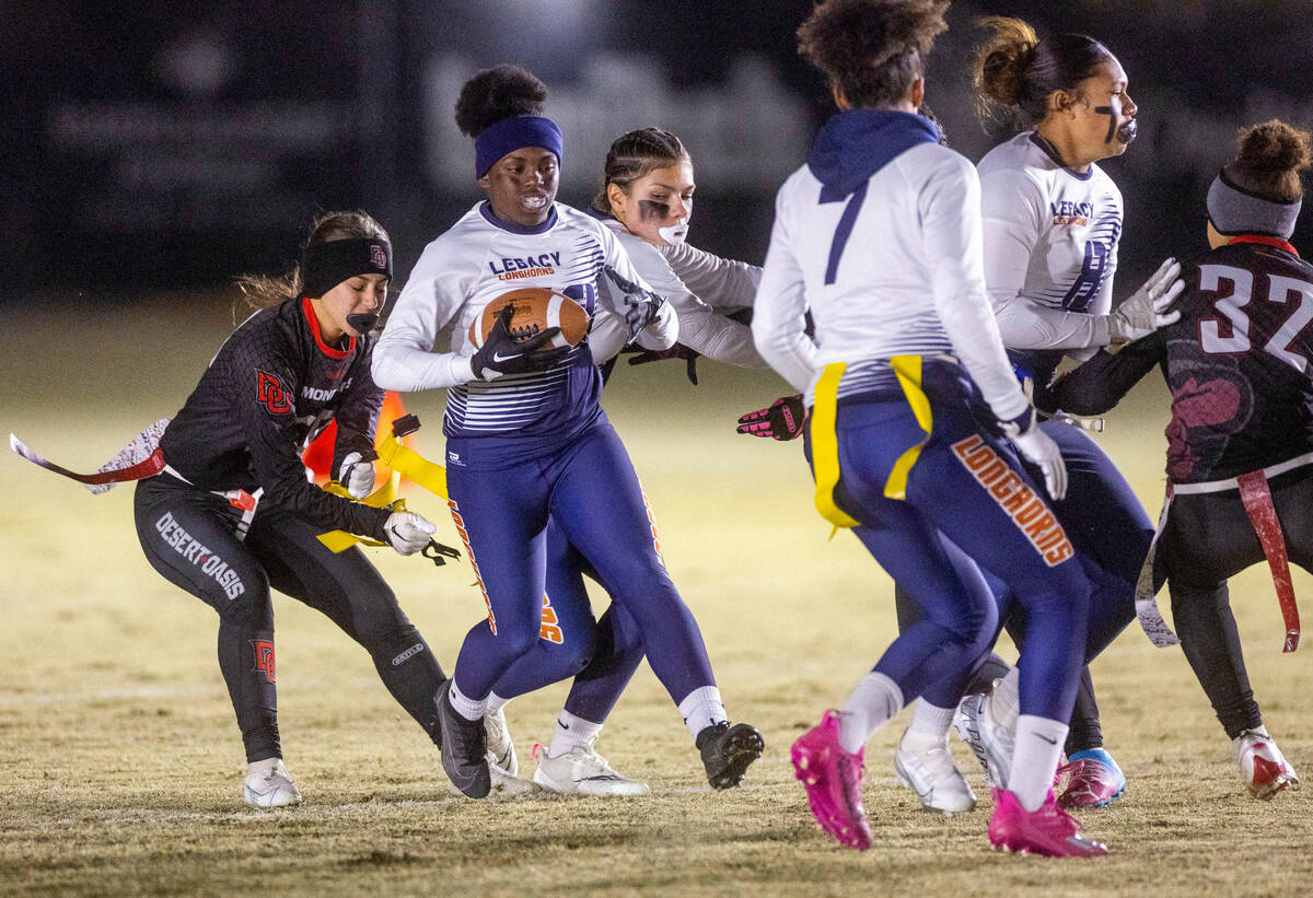 Desert Oasis' Fatima Topete (50) pulls the flag of Legacy's Mailaya Taylor as she runs the ball ...