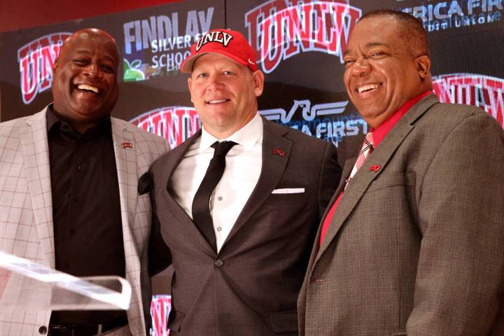 New UNLV football coach Barry Odom is introduced with Athletic Director Erick Harper, left, and ...