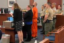 Shawn Eisenman, center in orange jumpsuit, is watched by multiple officers during an appearance ...