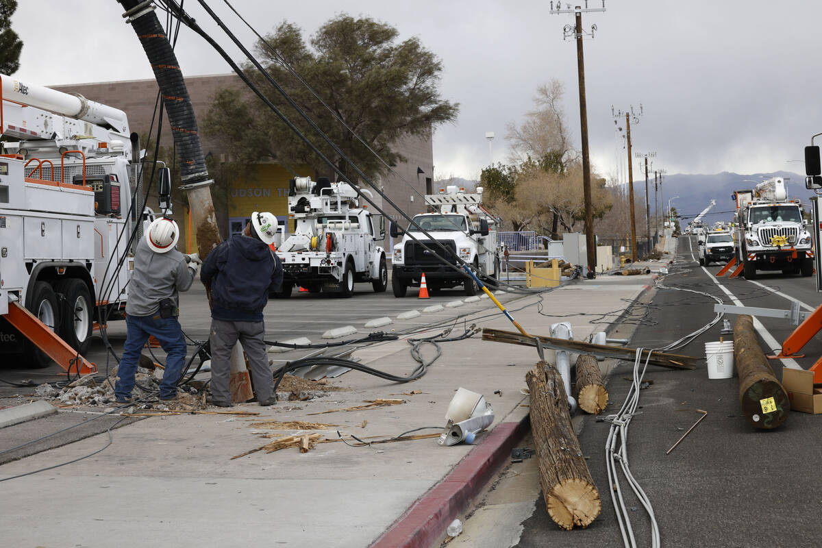 Energy crews repair downed power poles, Wednesday, Feb. 22, 2023, on Atlantic Street near Depar ...
