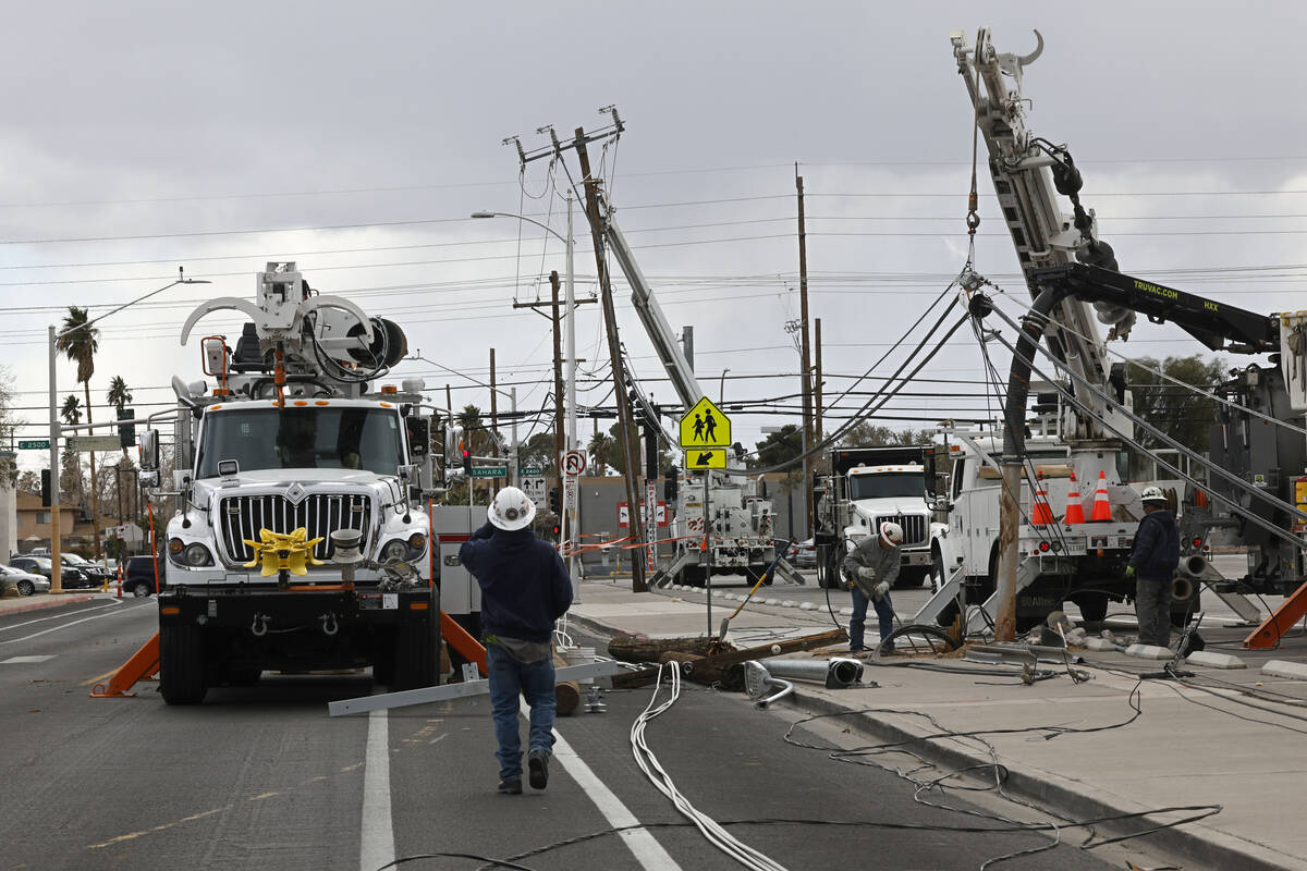Energy crews repair downed power poles, Wednesday, Feb. 22, 2023, on Atlantic Street near Depar ...