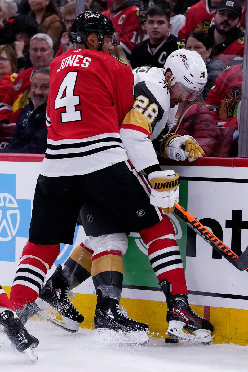 Vegas Golden Knights left wing William Carrier, right, is checked by Chicago Blackhawks defense ...