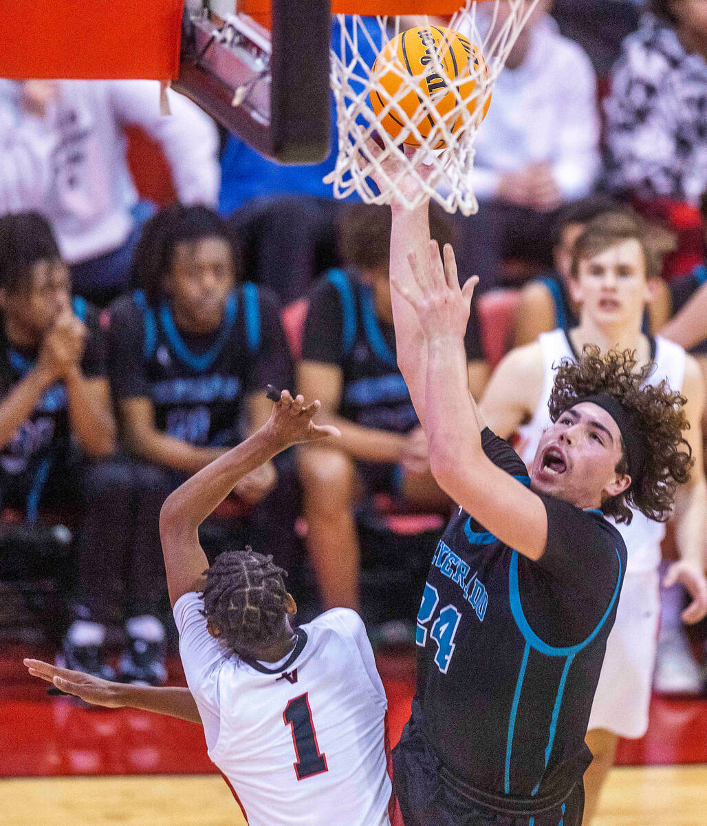 Silverado's Mike Andersen (24) drives strong to the hoop atop of Las Vegas' Naseer Sims (1) dur ...