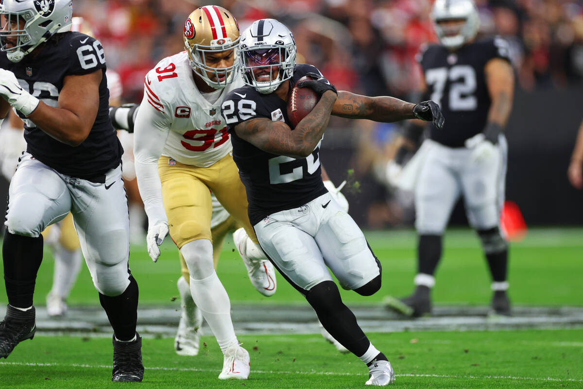 Raiders running back Josh Jacobs (28) runs the ball past San Francisco 49ers safety Tashaun Gip ...