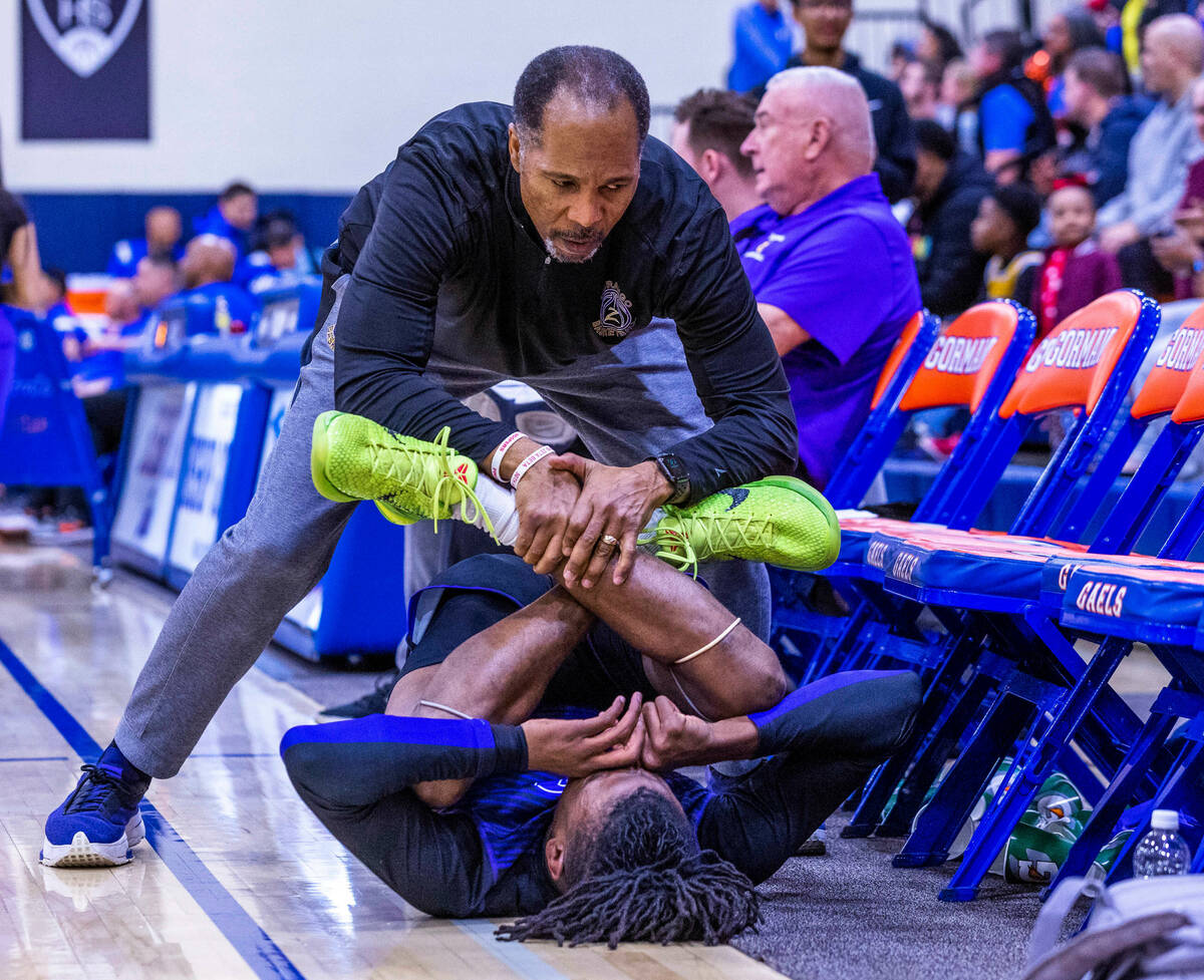 Durango assistant coach Mike Lee helps to stretch out guard Tylen Riley (10) before the first h ...