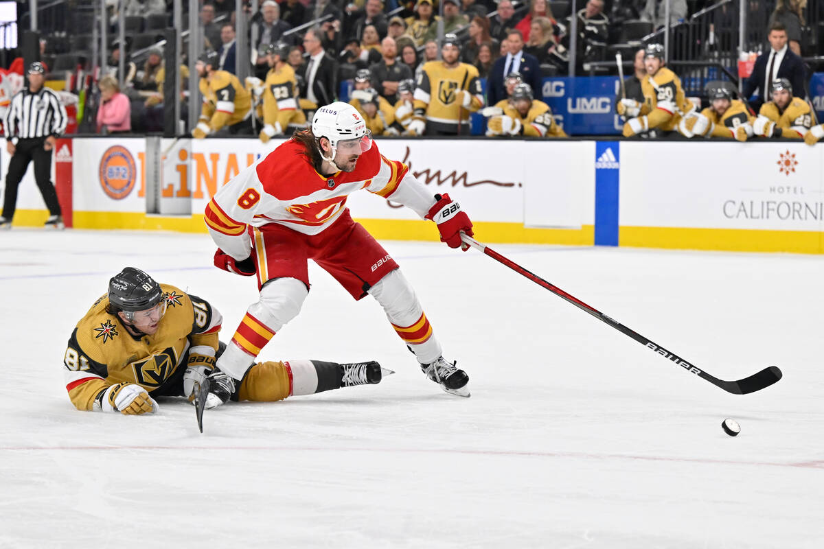 Calgary Flames defenseman Chris Tanev (8) steals the puck from Vegas Golden Knights right wing ...