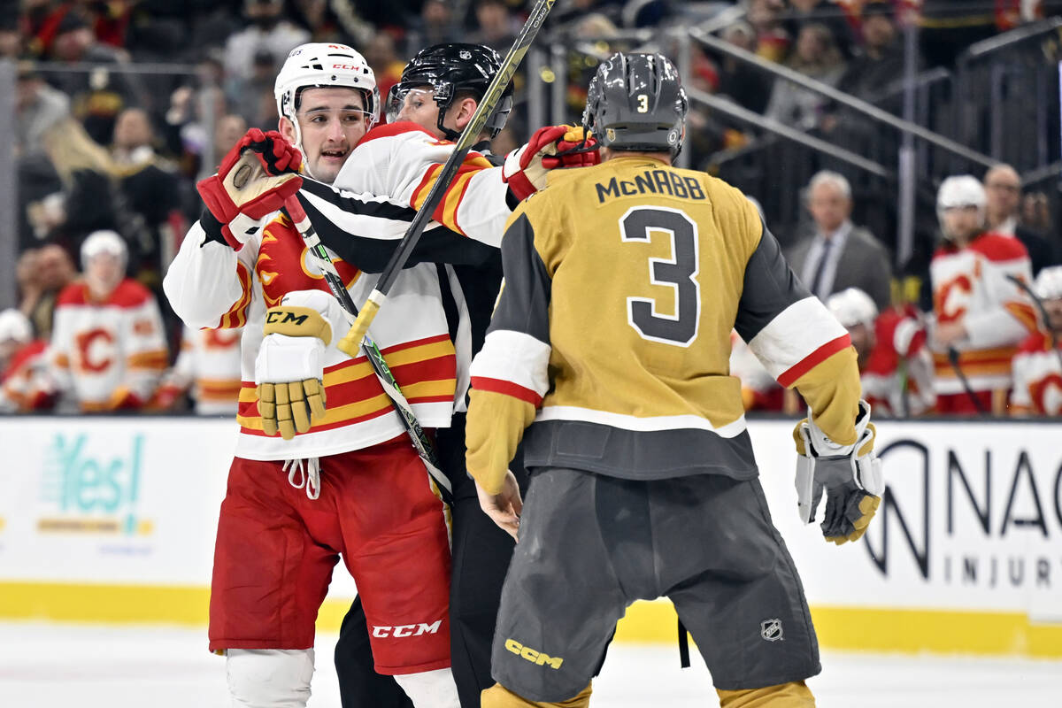 Calgary Flames defenseman Dennis Gilbert, left, throws a punch toward Vegas Golden Knights defe ...