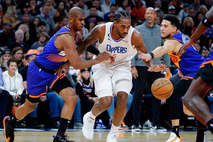 Phoenix Suns' Chris Paul, left, and Devin Booker, right, double-team Los Angeles Clippers' Kawh ...