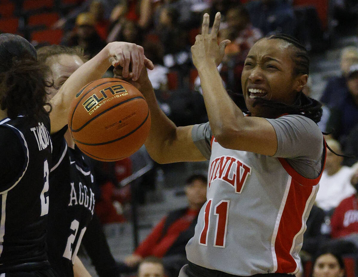 UNLV Lady Rebels guard Justice Ethridge (11) loses a ball under pressure from Utah State Aggies ...