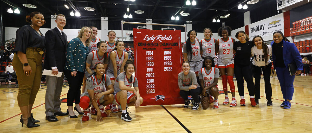 UNLV Lady Rebels players and coaches pose for photos with Mountain West championship banner af ...