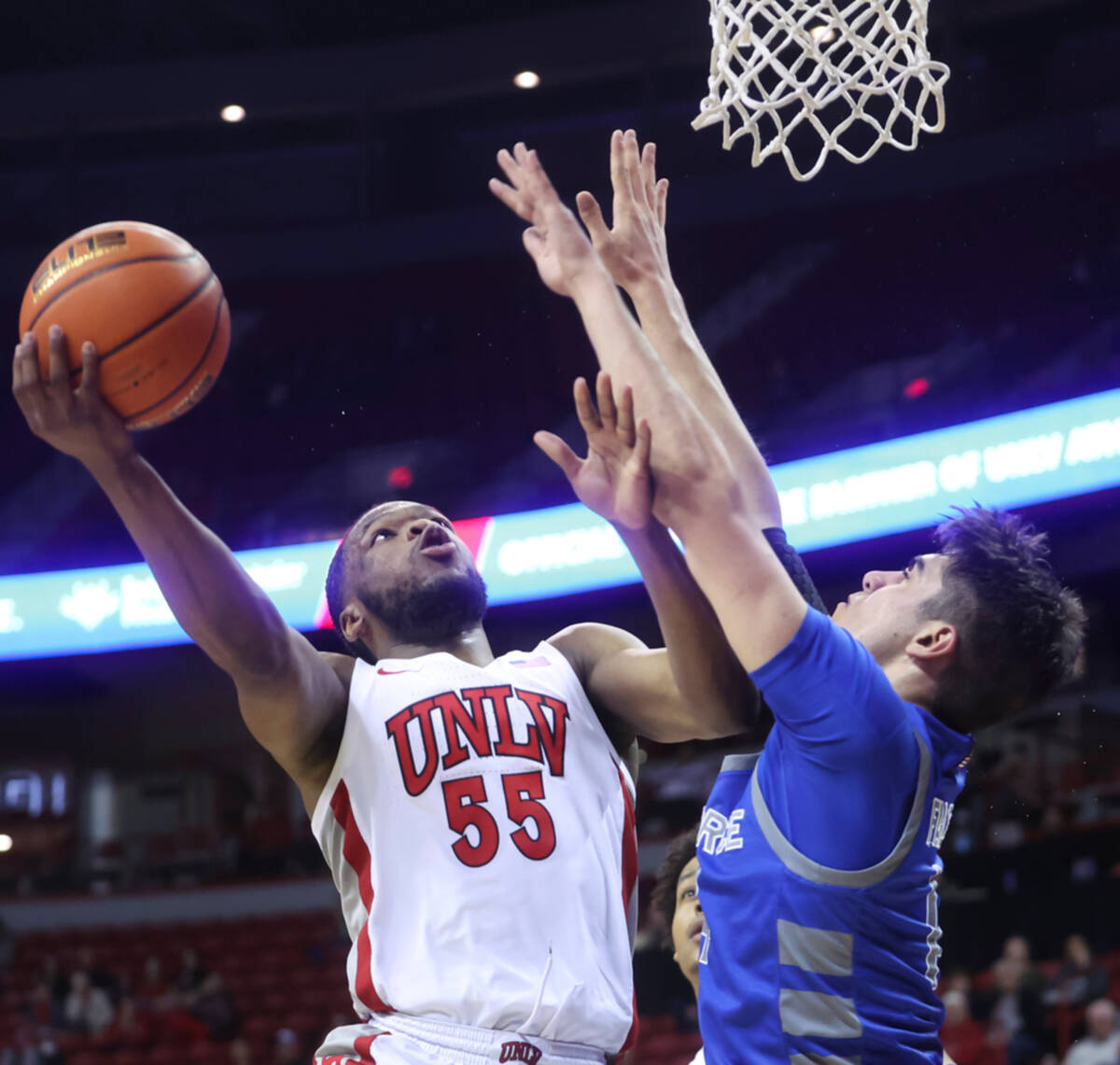 UNLV guard EJ Harkless (55) lays up the ball under pressure from Air Force Falcons forward Beau ...