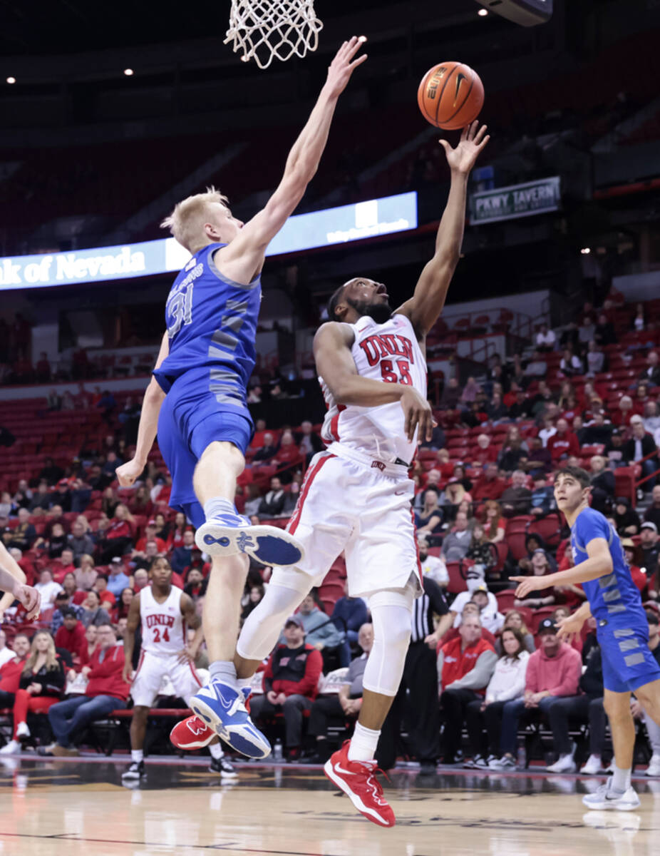 UNLV guard EJ Harkless (55) lays up the ball under pressure from Air Force Falcons forward Ryti ...