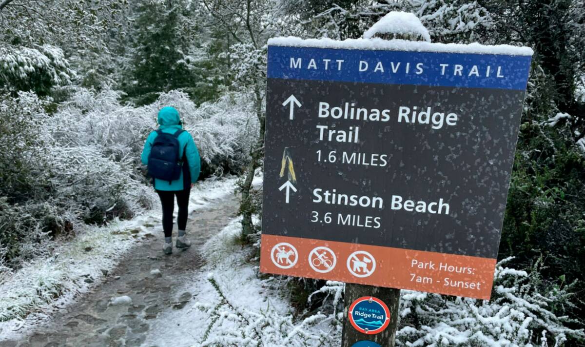 A person walks up a trail at snow-covered Mount Tamalpais State Park in Mill Valley, Calif., Fr ...